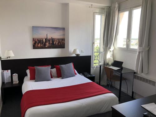 サン・クルーにあるパリ サン クルー オテルの大きなベッドとデスクが備わるホテルルームです。