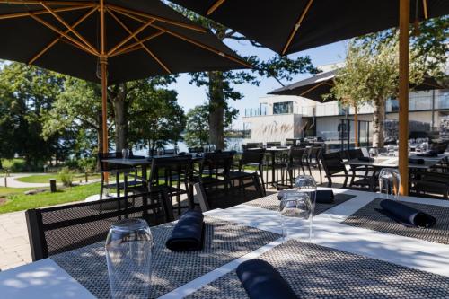 a table with chairs and umbrellas at a restaurant at Golden Lakes Hotel in Boussu-lez-Walcourt