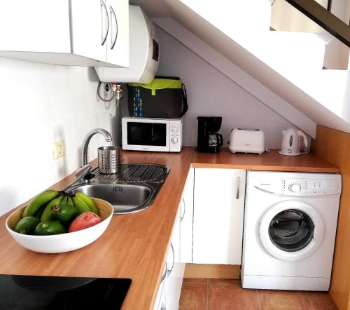 a kitchen with a sink and a bowl of fruit at Apartamento La Caleta El Hierro Island terrace with incredible views in La Caleta