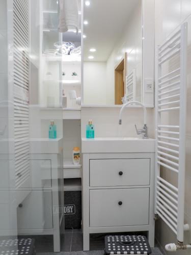 ザグレブにあるApartman Delux Addaの洗面台と鏡のある白いバスルーム