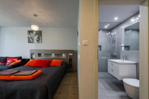 a bedroom with a large bed and a bathroom at Apartment Słoneczny Gródek 51 in Gródek Nad Dunajcem