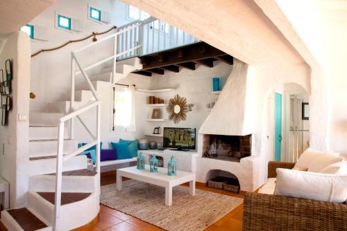 ein Wohnzimmer mit einer Treppe und einem Kamin in der Unterkunft San Colomban in Sant Lluís