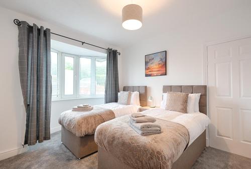 a bedroom with two beds and a window at Spacious house in Swansea TV in every bedroom in Swansea