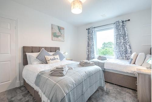 a bedroom with two beds and a window at Large 4BR House Near Retail Parks & M4 in Swansea