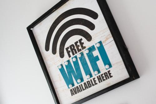 a sign for a free wifi sign on a wall at Large 4BR House Near Retail Parks & M4 in Swansea