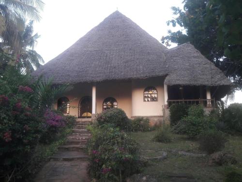 
a large white house with a large window at Masai Paradise Cottages in Diani Beach
