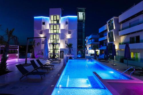 una piscina frente a un edificio por la noche en Boutique Residence Cosmopolis, en Bibinje