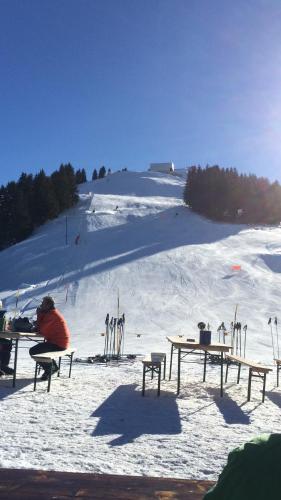 a person sitting at picnic tables in the snow at Chalet Aloa in Adelboden
