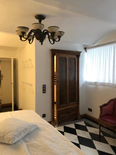a bedroom with a bed and a chandelier at Sarah's Altstadt Oase Salzburg in Salzburg