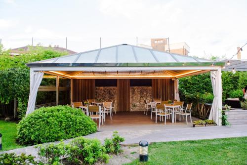 a pavilion with tables and chairs in a garden at Gran Hotel Victoria in Santander