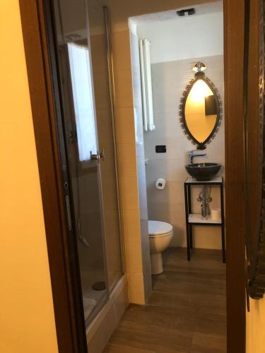 a bathroom with a toilet and a sink and a mirror at La Casa di Anna in Delebio
