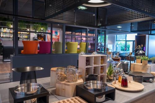 a restaurant with colorful chairs and a counter at Hotel Mercure Toulouse Centre Compans in Toulouse