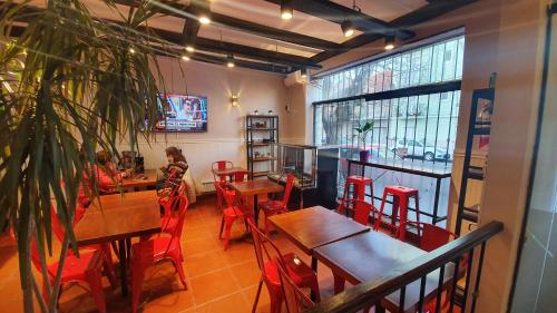 a restaurant with wooden tables and red chairs at Hotel Positano in Mar del Plata