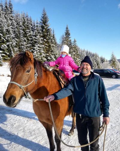 a man standing next to a horse with a little girl on it at Ranč pod Ostrou Skalou in Stratená