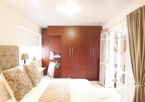 a bedroom with a bed and a wooden cabinet at Inn-Style in Cape Town