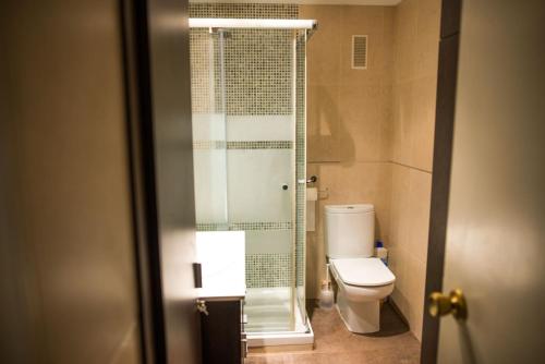 a bathroom with a toilet and a glass shower at Acogedor apartamento en primera linea de playa in Salou