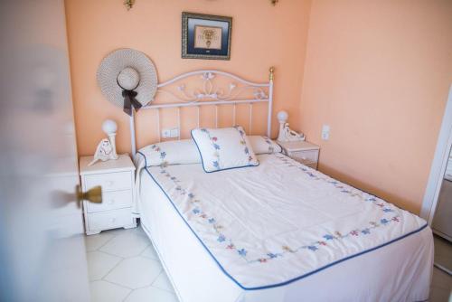 a bedroom with a white bed with a fan on it at Acogedor apartamento en primera linea de playa in Salou