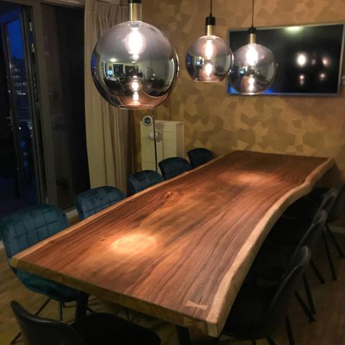 a wooden table in a room with chairs and lights at Scheveningen Diamond View Beach and Harbour in Scheveningen