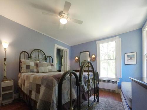 a bedroom with a bed and a ceiling fan at The Fox and Owl Inn in Port Jefferson