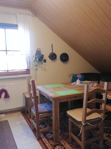 a dining room with a wooden table and chairs at Ruhe geniessen bei Kulbes in Doberschütz