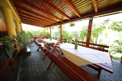 a patio with a table and benches and plants at Pensiunea Criveanu in Horezu