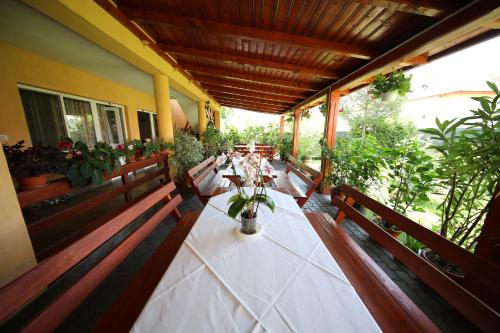 a porch with a table with flowers on it at Pensiunea Criveanu in Horezu