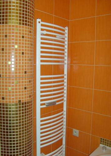 a bathroom with a shower with brown tiled walls at Apartmán Hodruša-Hámre in Hodruša