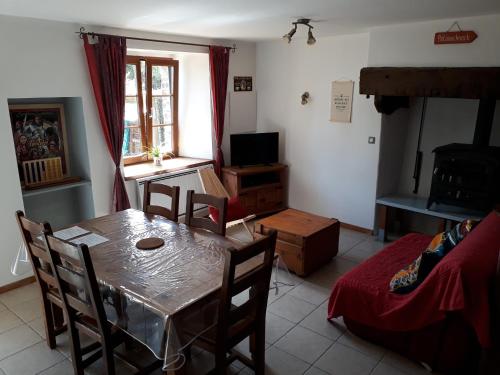 a living room with a table and chairs and a television at La Lyonnais in Pleslin-Trigavou