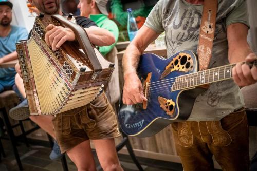 a man is holding a guitar next to another man at Hotel Platz in Ortisei
