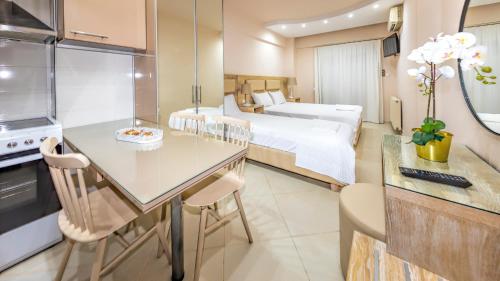 um quarto de hotel com uma cama e uma cozinha com uma mesa em LE MONDE Seaview Suites em Kallikrateia