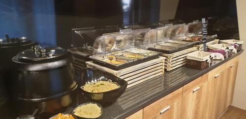 a buffet line with many trays of food at Baobab Suites in Siófok
