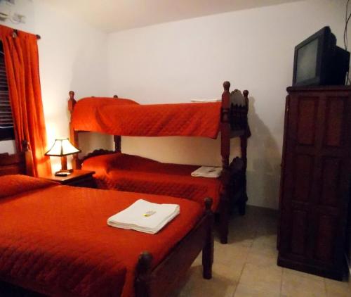 a hotel room with two beds and a tv at Portal De Los Valles in Chicoana