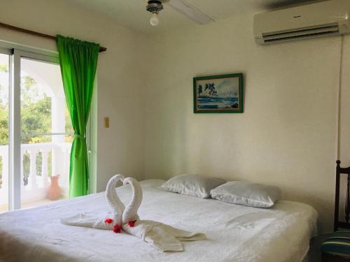 Un dormitorio con una cama con dos cisnes. en Peaceful Ocean View Studio en San Felipe de Puerto Plata