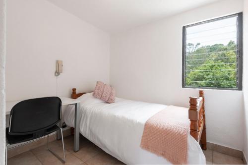メキシコシティにあるCuarto en las Lomasのベッドルーム1室(ベッド1台、椅子、窓付)