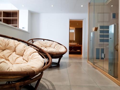 a living room with two chairs and a glass door at Mosella Suite Hotel in Sottomarina