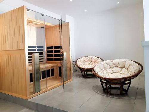 a room with two chairs and a table and a glass partition at Mosella Suite Hotel in Sottomarina