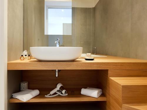 a bathroom with a white sink and a mirror at Mosella Suite Hotel in Sottomarina