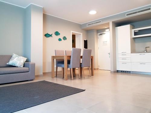 a kitchen and dining room with a table and chairs at Mosella Suite Hotel in Sottomarina