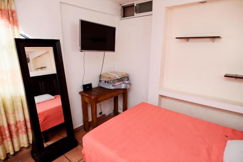 a bedroom with a mirror and a bed and a tv at Hotel María Elena in Durango