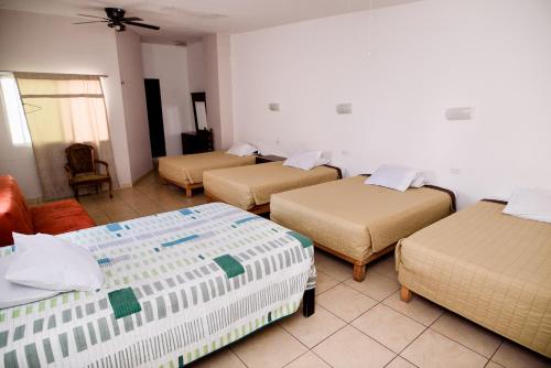 a room with four beds in a room at Hotel María Elena in Durango