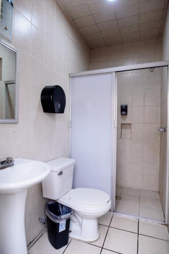 a bathroom with a shower and a toilet and a sink at Hotel María Elena in Durango