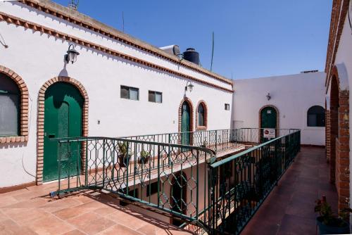 a courtyard of a building with green doors at Hotel María Elena in Durango