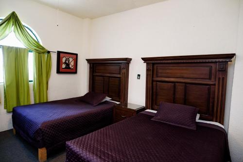a hotel room with two beds and a window at Hotel María Elena in Durango