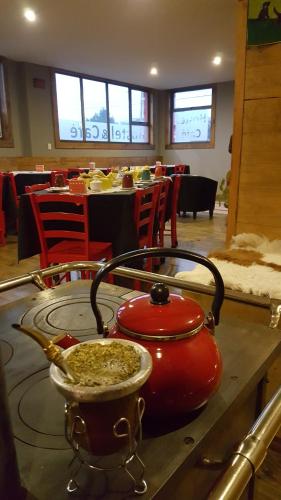 a red tea kettle on a table in a restaurant at Hostal Esquina Patagónica in Coihaique