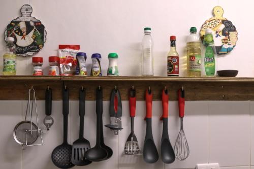 a shelf with cooking utensils hanging on a wall at Hostal Esquina Patagónica in Coihaique