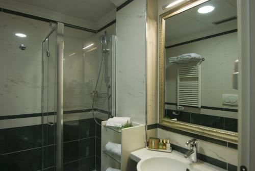 a bathroom with a sink and a shower and a mirror at JR Hotels Oriente Bari in Bari