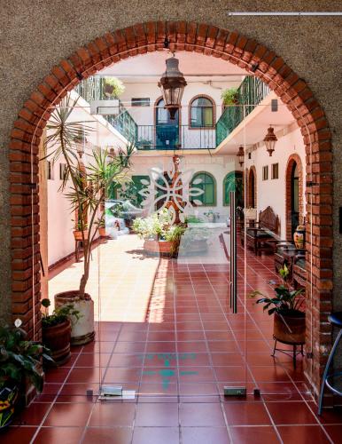 an arched entryway to a house with plants at Hotel María Elena in Durango
