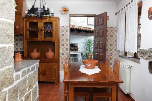 een eetkamer met een houten tafel en een aanrecht bij Casa da Eira in Lousã