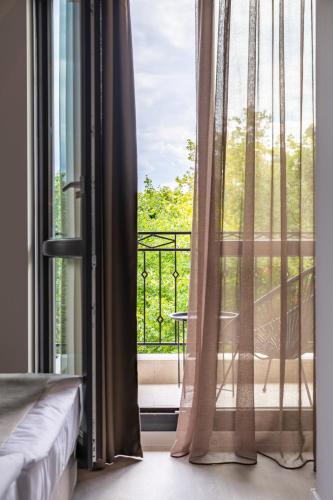a bedroom with a window with a view of a balcony at Primorski Hotel in St. St. Constantine and Helena