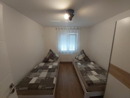 two beds in a small room with a window at Apartment Claudia in Sinsheim
